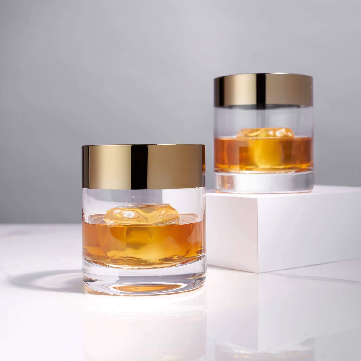 Irving Bronze-Rimmed Crystal Lowball Tumblers set of 2 with whiskey and ice, showcasing mid-century modern design.