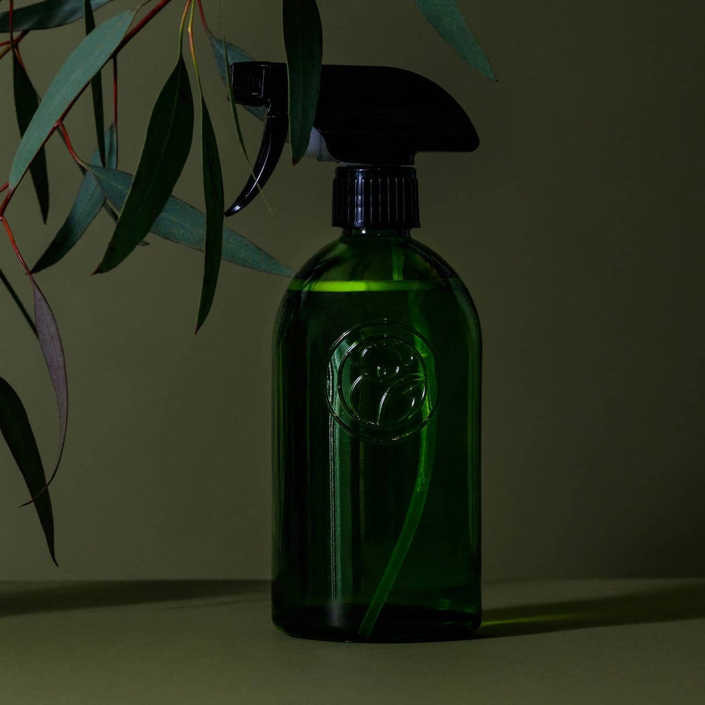 Apothecary recycled glass trigger spray bottle ideal for Koala Eco products, set against a green background with foliage.