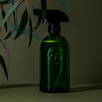 Apothecary recycled glass trigger spray bottle ideal for Koala Eco products, set against a green background with foliage.