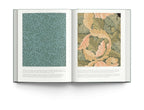 Open book featuring wallpaper designs by William Morris, showcasing detailed patterns in elegant colors.