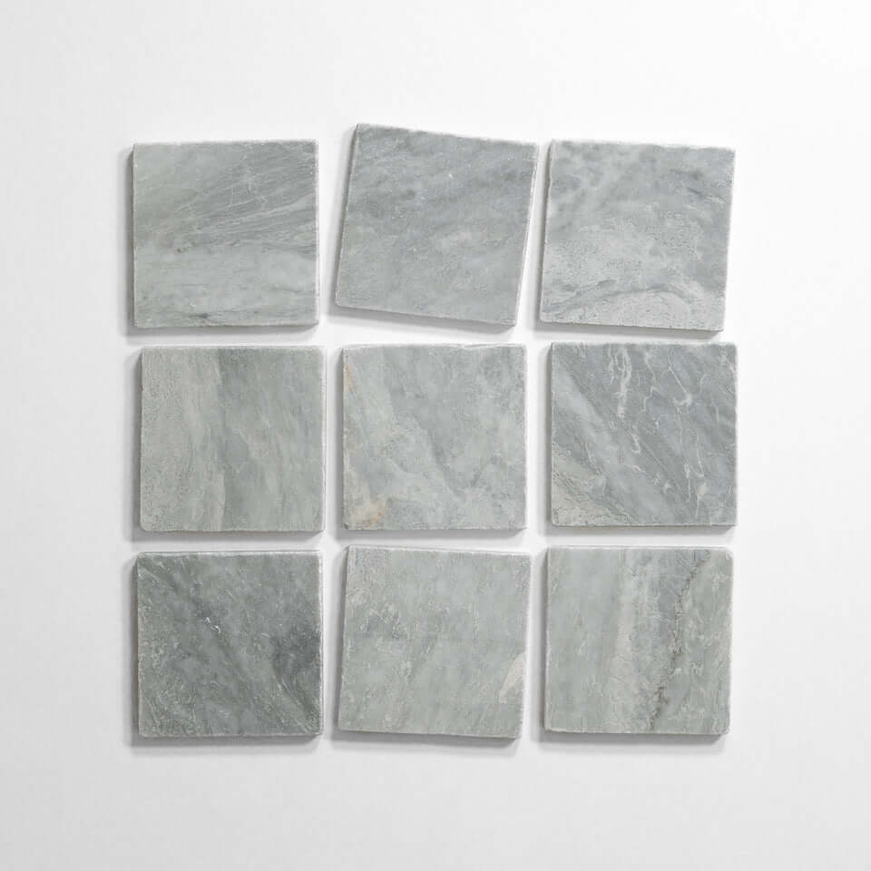 Bardiglio 4x4 tumbled marble tile display, featuring nine light gray tiles arranged in a grid pattern.
