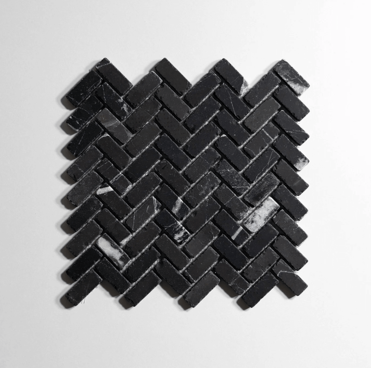 Nero St. Gabriel marble tile, herringbone pattern, black with white veining