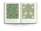 Open book displaying intricate wallpaper designs by William Morris, showcasing floral patterns and rich colors.