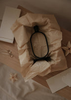 Eternal Oval Candle Holder in minimalist packaging on a wooden surface with decorative elements.