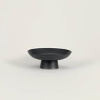 Matte black ceramic footed bowl perfect for serving fruits or decorative items, featuring a clean black finish.